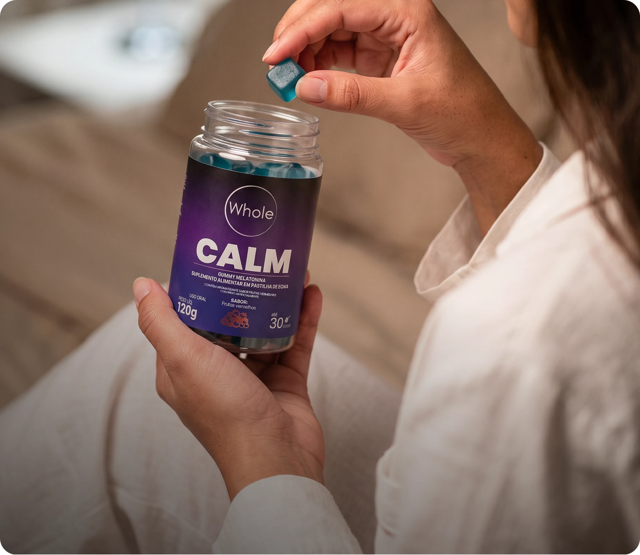 Whole CALM — cápsula de melatonina em goma sendo aberta na mão